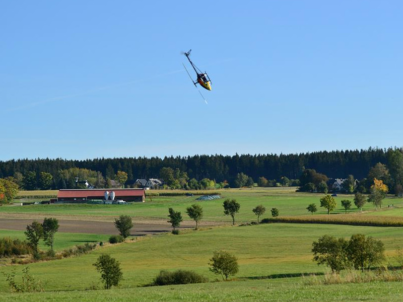 Bei herrlichem Wetter turnt der ferngesteuerte Helikopter. Im Hintergrund Baumersreuth.